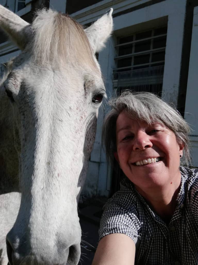 Marie Bertrand prenant la pose avec son cheval, suite à une communication intuitive animale.